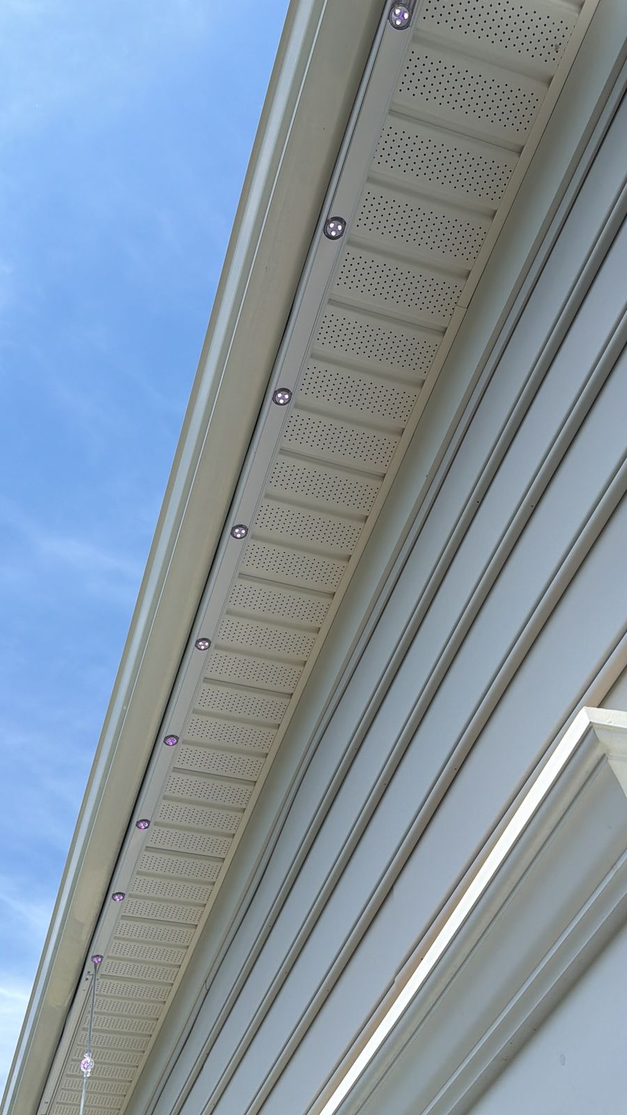 Permanent lighting track installed on soffit during daytime — nearly invisible