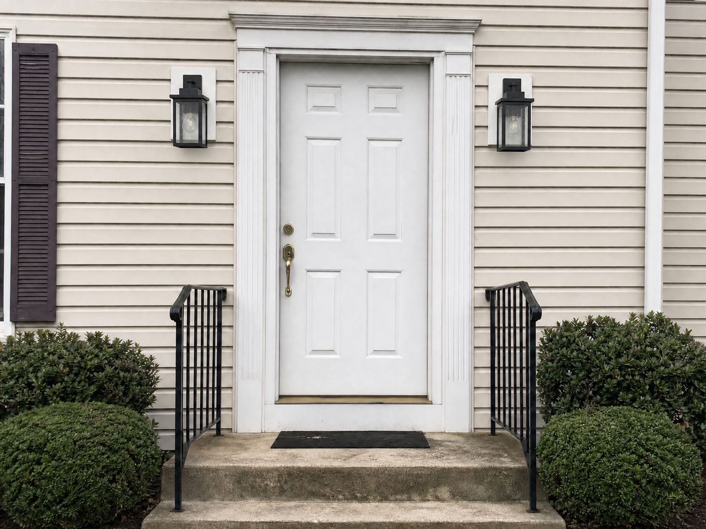 New exterior sconce on a vinyl-sided entry